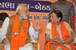 Modi talking to a woman; both are seated.