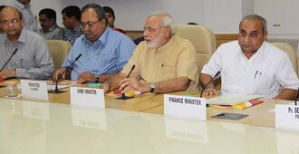 Modi flanked by three other men at a table
