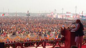 Modi addressing a large crowd from a podium